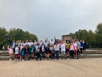 a group of people standing in front of a fountain