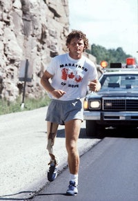 a man in a t - shirt running down a road